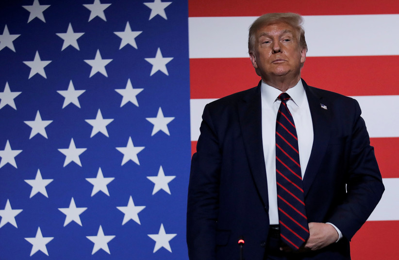 US President Donald Trump stands in front of a US flag as he participates in a roundtable on donating plasma during a visit to the American Red Cross National Headquarters in Washington, US, July 30, 2020 (photo credit: REUTERS/CARLOS BARRIA/FILE PHOTO)