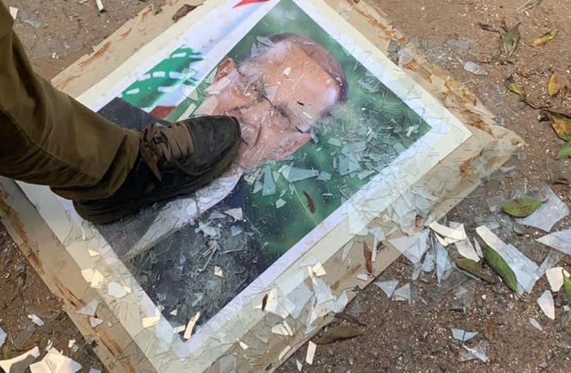 A demonstrator steps on a picture of Lebanese President Michel Aoun, at the Ministry of Foreign Affairs during a protest following Tuesday's blast, in Beirut, Lebanon August 8, 2020 (photo credit: REUTERS/ELLEN FRANCIS)