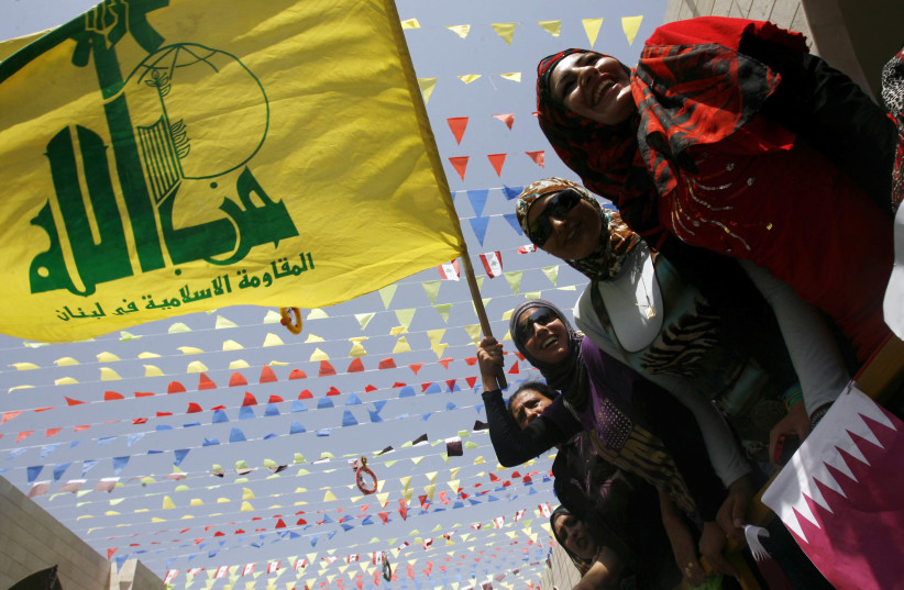 Les résidents tiennent les drapeaux du Hezbollah et du Qatar lors de la visite de l'émir du Qatar, Cheikh Hamad bin Khalifa al-Thani, au village de Bint Jbeil, dans le sud du Liban, le 31 juillet 2010. (Crédit photo: REUTERS)
