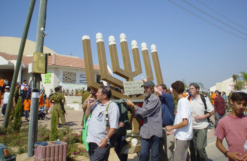 SETTLERS CARRY out the giant menorah from the synagogue at Netzarim, the last Gaza settlement to be evacuated, August 22, 2005 (credit: ARIEH O’SULLIVAN)