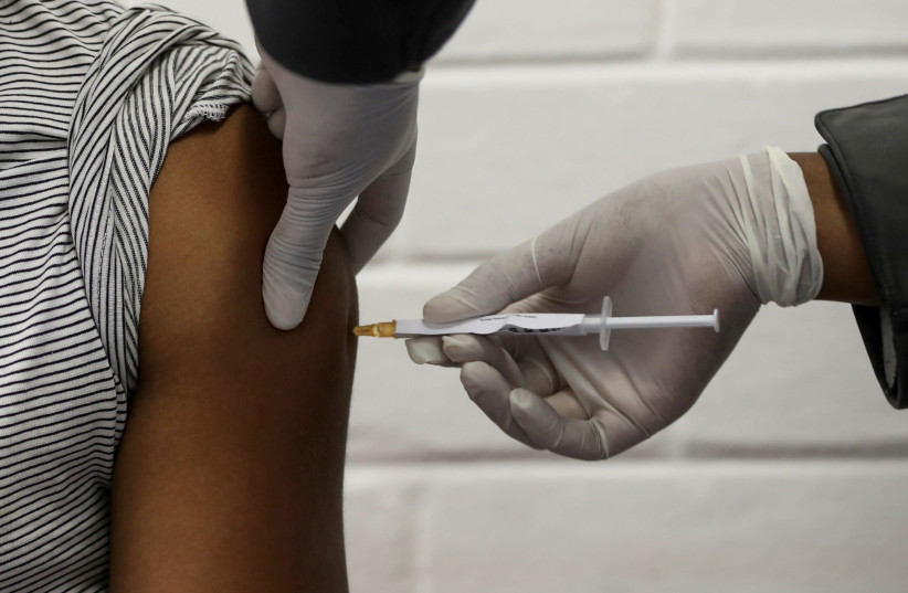 A volunteer receives an injection in a human clinical trial for a potential vaccine against the novel coronavirus, at the Baragwanath hospital in Soweto, South Africa, June 24, 2020 (photo credit: REUTERS/SIPHIWE SIBEKO)