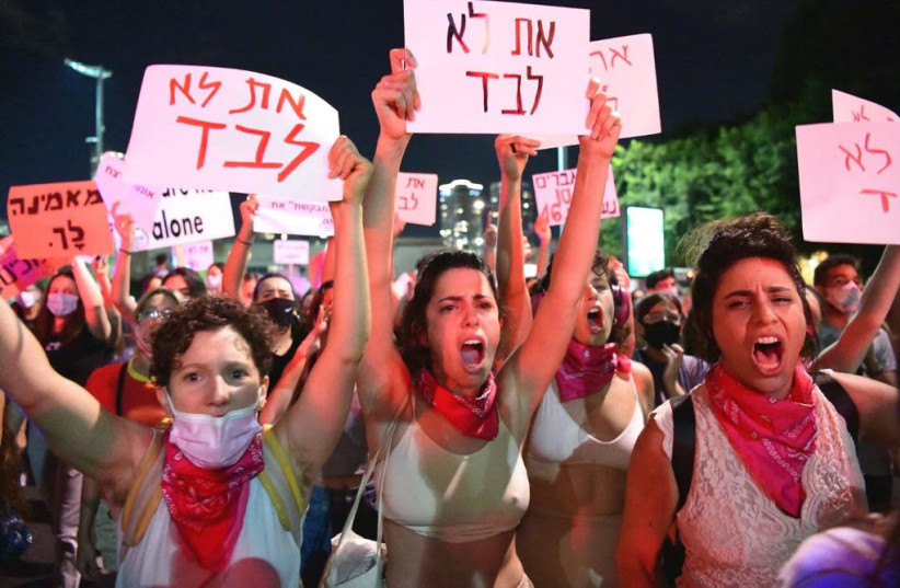 Women's March protesters hold signs saying, "You are not alone" after a 16-year-old girl was gang-raped in Eilat. (photo credit: AVSHALOM SASSONI)