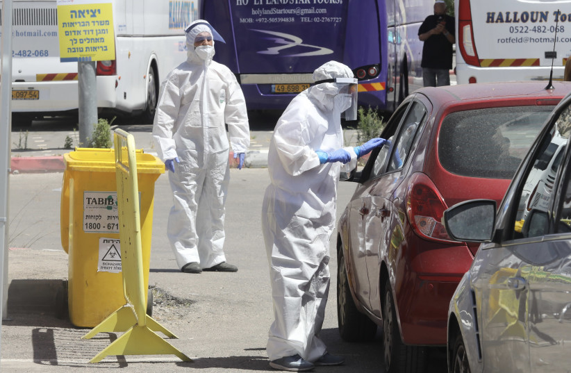 Inspectors conduct coronavirus tests at a checkpoint in Jerusalem (photo credit: MARC ISRAEL SELLEM)