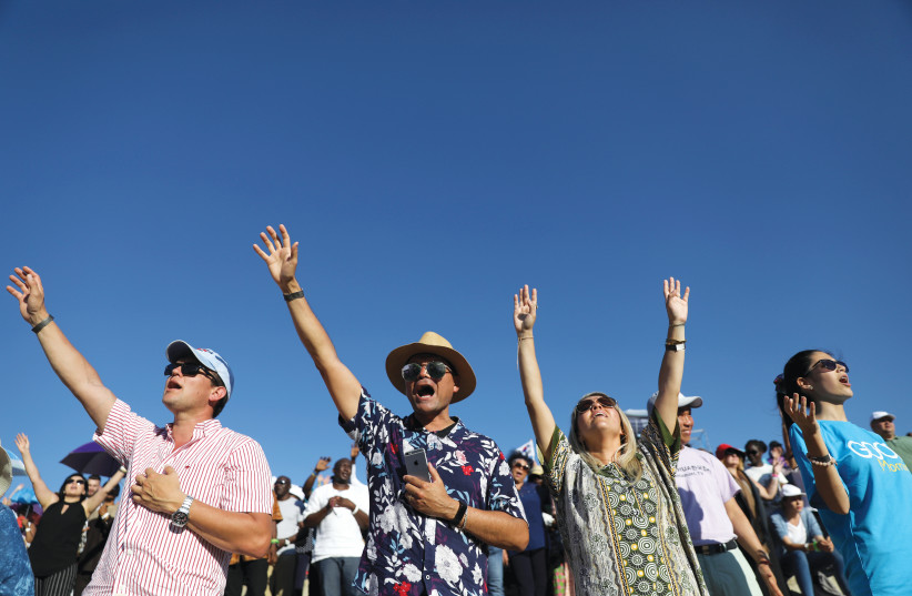 EVANGELICAL CHRISTIAN pilgrims and tourists reach for the sky at a 2019 religious retreat in Nazareth (photo credit: AMMAR AWAD/REUTERS)