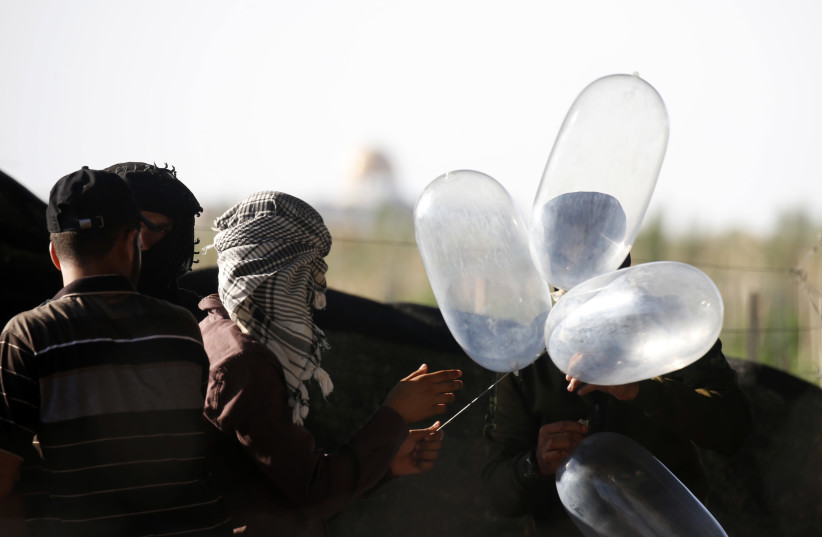 Palestinian men prepare to release balloon-borne explosive and incendiary devices towards Israeli lands near Rafah, along the Israel-Gaza border, on August 21, 2020.  (photo credit: FADI FAHD/FLASH90)