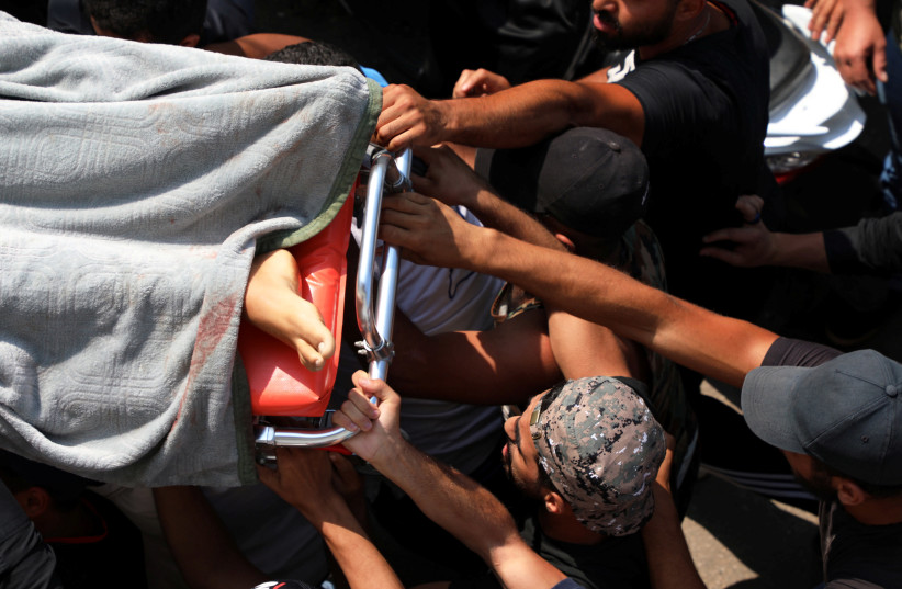 Mourners hold the body of a boy who died during Thursday's clashes, during his funeral in Khaldeh, Lebanon August 28, 2020. (photo credit: REUTERS/MOHAMED AZAKIR)