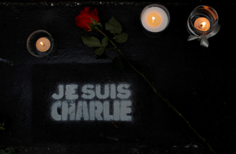 Flowers and candles are seen outside the satirical newspaper Charlie Hebdo's former office on the fifth anniversary of the attack and a siege at a Kosher supermarket which killed 17 people in Paris, France January 7, 2020 (photo credit: REUTERS/GONZALO FUENTES)