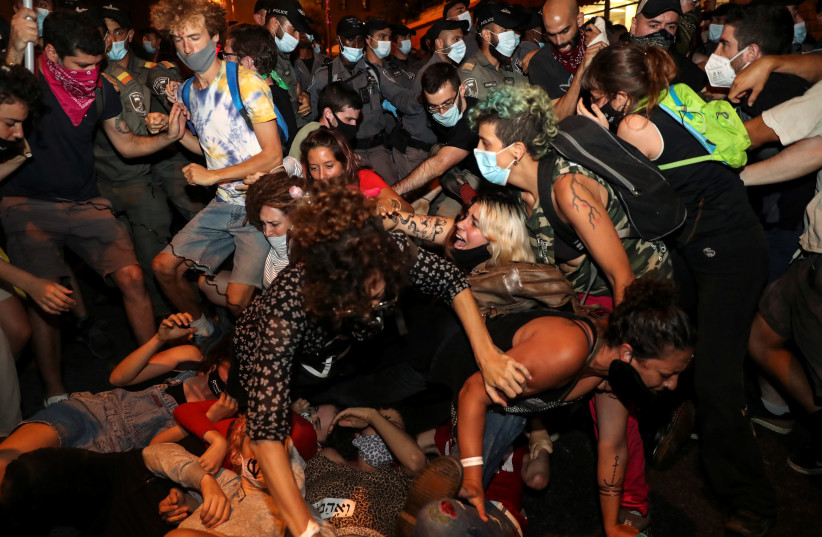 Demonstrators react as police officers start detaining them during a protest against Israeli Prime Minister Benjamin Netanyahu's alleged corruption and economic hardship stemming from lockdown during the coronavirus disease (COVID-19) crisis, near his residence in Jerusalem, August 30, 2020 (photo credit: REUTERS/AMMAR AWAD)