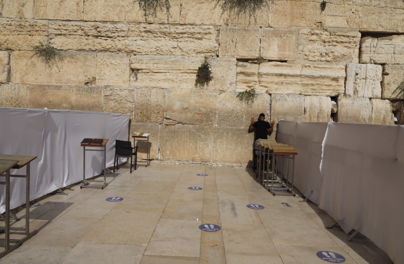 Man prays at Western Wall amid coronavirus (photo credit: MARC ISRAEL SELLEM)
