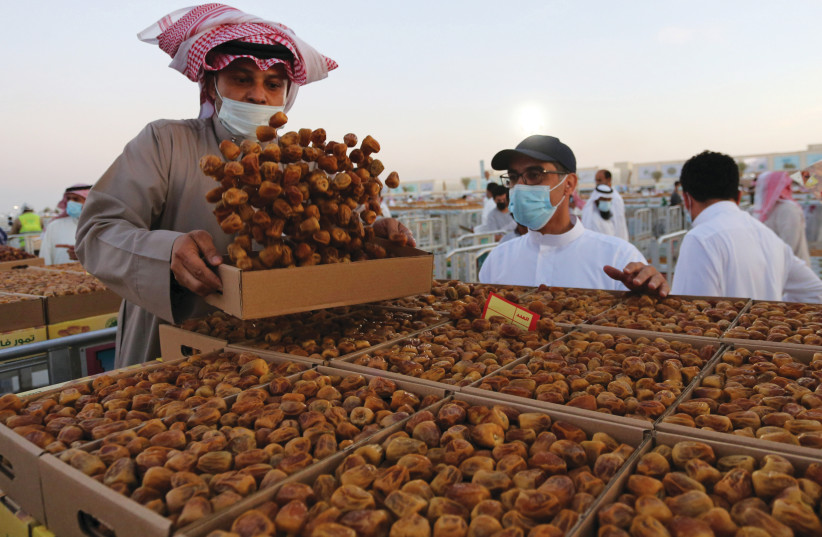 STAYING LOCAL: A Saudi farmer displays dates to customers during Unaizah Season for Dates, in Saudi Arabia on August 15 (photo credit: AHMED YOSRI/ REUTERS)
