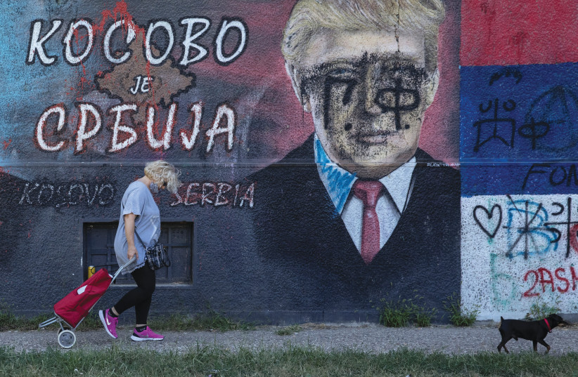 A WOMAN passes a mural depicting US President Donald Trump and text reading ‘Kosovo is Serbia,’ in Belgrade, Serbia, on September 4 (photo credit: MARKO DJURICA/REUTERS)