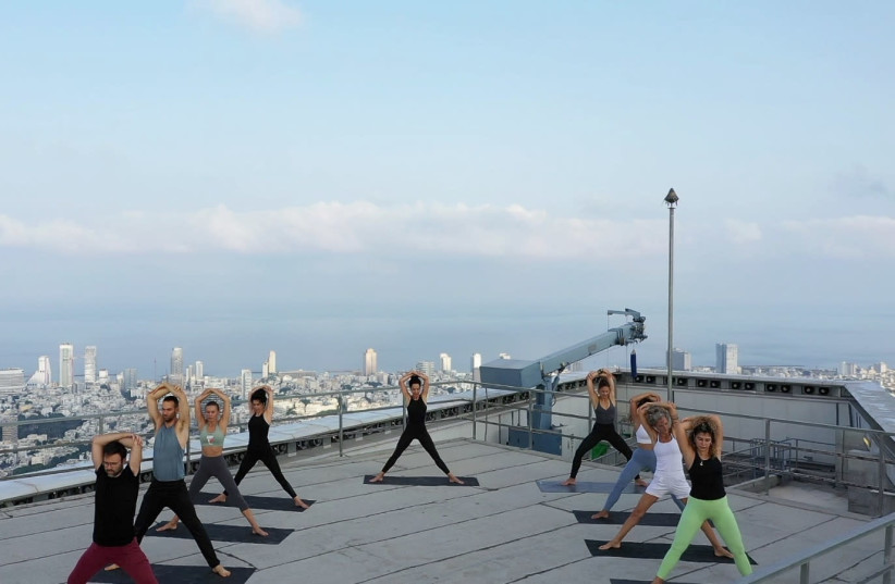 Yoga lesson taking place on the 63rd floor of one of the Azrieli towers (photo credit: ELDAD ALONI AND JONATHAN HENNING)