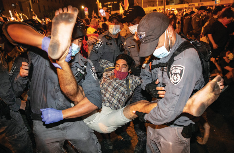 POLICE OFFICERS remove demonstrators during a protest against Prime Minister Benjamin Netanyahu in Jerusalem last week. (photo credit: OLIVIER FITOUSSI/FLASH90)