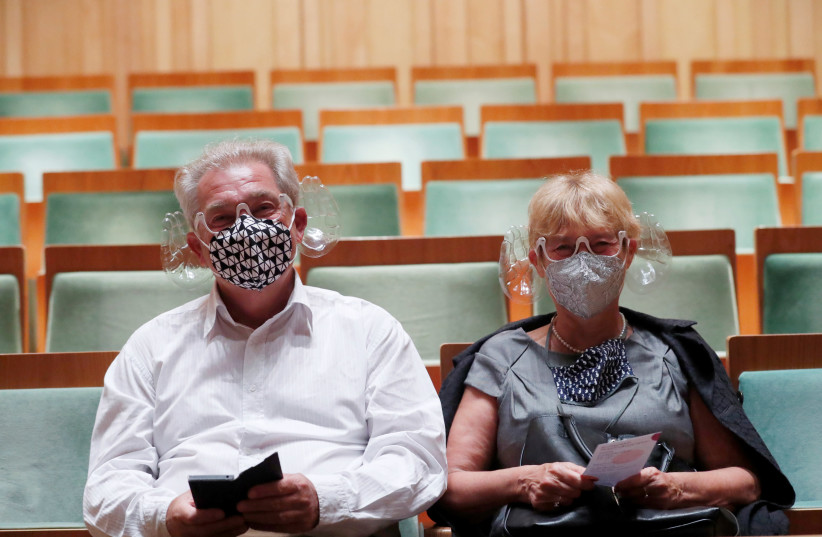 A couple wears orchestra conductor Ivan Fischer's acoustic mask at the Mupa Budapest in Budapest, Hungary, September 11, 2020 (photo credit: REUTERS/BERNADETT SZABO)