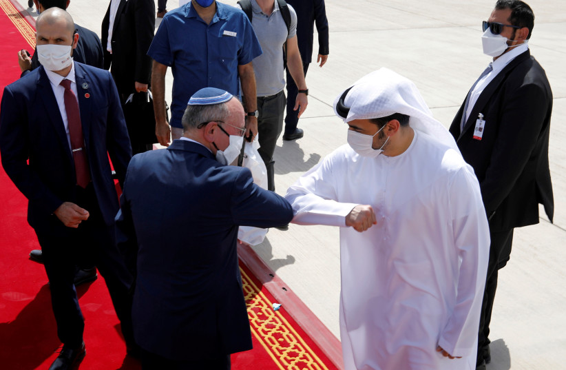 Israeli National Security Advisor Meir Ben-Shabbat elbow bumps with an Emirati official as he makes his way to board the plane to leave Abu Dhabi, United Arab Emirates September 1, 2020 (photo credit: REUTERS/NIR ELIAS)