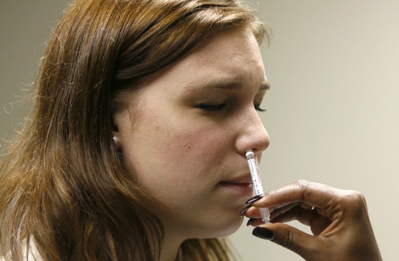 George Washington University student Jessica Hirsh is given the H1N1 flu nasal spray vaccine at the Student Health Service clinic in Washington, November 19, 2009 (credit: REUTERS/HYUNGWON KANG)