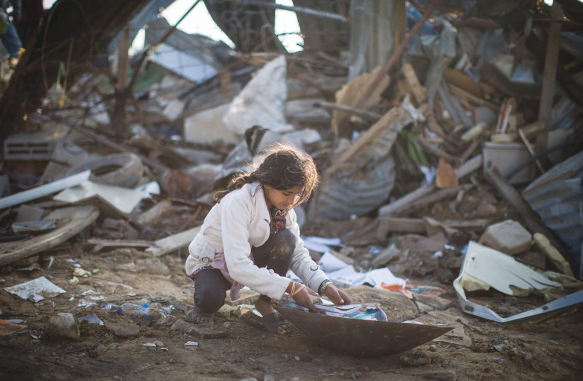 A YOUNG WOMAN picks through the ruins of a demolished home in the Bedouin village of Umm al-Hiran in the Negev in 2017.  (photo credit: HADAS PARUSH/FLASH90)
