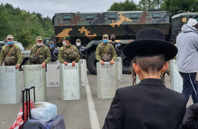 Jewish pilgrims, who plan to enter Ukraine from the territory of Belarus, gather in front of Ukrainian service members near Novi Yarylovychi crossing point in Chernihiv Region, Ukraine September 15, 2020 (photo credit: BRESLEV LIVE/HANDOUT VIA REUTERS)
