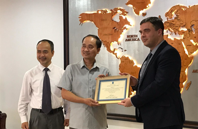 Ambassador Nadav Eschar offers an award certificate to his Vietnamese counterparts. (photo credit: ISRAELI EMBASSY IN HANOI)