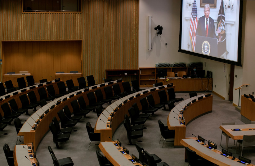 US President Donald Trump is seen on a screen broadcasting to an empty conference room as he delivers a pre-recorded address to the 75th annual UN General Assembly at United Nations headquarters. September 22, 2020 (photo credit: REUTERS/MIKE SEGAR)