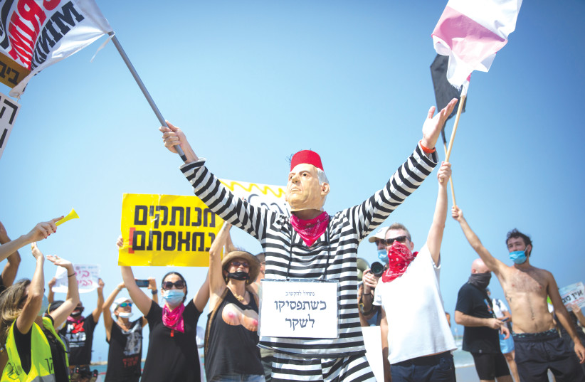 ISRAELIS DEMONSTRATE against the three-week nationwide lockdown and Prime Minister Benjamin Netanyahu, on a Tel Aviv beach, September 19, 2020 (photo credit: MIRIAM ALSTER/FLASH90)