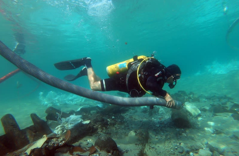Diver investigates rare masthead from ancient shipwreck found in northern Israel (photo credit: AMIR YURMAN)