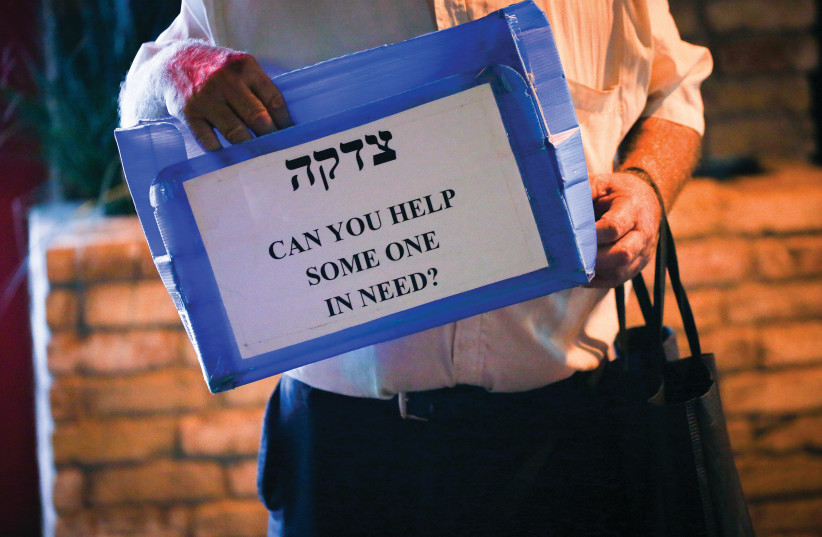 THE BEST way to fight the pandemic is to pass on kindness: to give tzedaka to those who have lost their jobs, to help elderly people who cannot go out to shop, to make a shiva minyan in a park opposite a mourner’s house (photo credit: DAVID COHEN/FLASH 90)