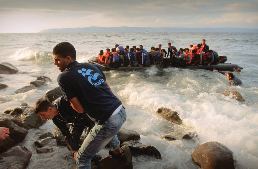 ISRAAID VOLUNTEERS rescue refugees off the coast of Greece. (photo credit: LIOR SPERANDEO)