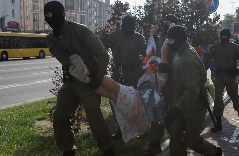Belarusian law enforcement officers detain a woman during an opposition rally to reject the presidential election results and to protest against the inauguration of President Alexander Lukashenko in Minsk, Belarus September 26, 2020.  (photo credit: REUTERS/STRINGER)