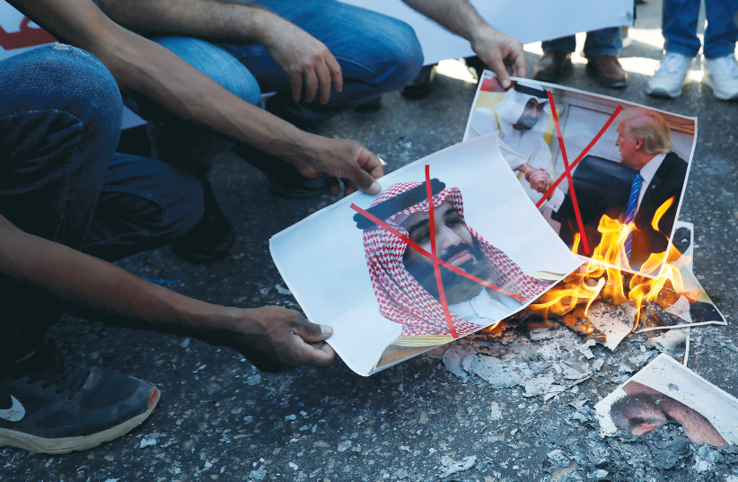 PROTESTERS BURN pictures of US President Donald Trump, Abu Dhabi Crown Prince Mohammed bin Zayed al-Nahyan and Saudi Arabia’s Crown Prince Mohammed bin Salman, in Ramallah last month.  (photo credit: MOHAMAD TOROKMAN/REUTERS)