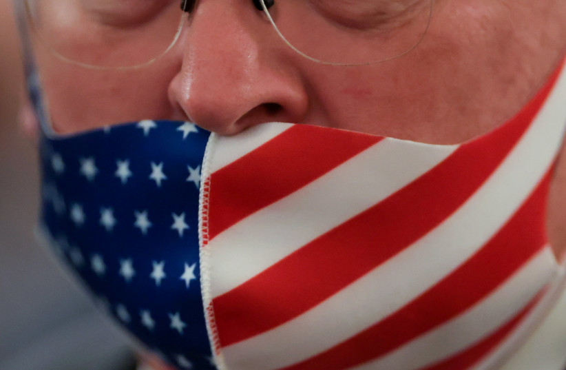 A participant wears his face mask under his nose as he attends US President Donald Trump’s signing ceremony for HR 1957, the Great American Outdoors Act, at the White House in Washington, US, August 4, 2020 (photo credit: REUTERS/JONATHAN ERNST)
