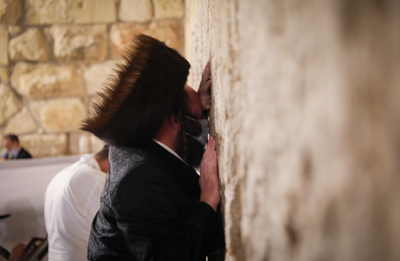 An ultra-Orthodox (haredi) man prepares for Yom Kippur, praying at the Western Wall in Jerusalem's Old City, September 26, 2020 (photo credit: YONATAN SINDEL/FLASH 90)