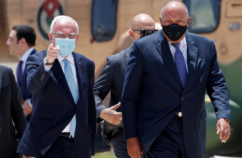 Egyptian Foreign Minister Sameh Shoukry walks with Palestinian Foreign Minister Riyad al-Maliki upon his arrival to meet with President Mahmoud Abbas in Ramallah in the Israeli-occupied West Bank July 20, 2020 (photo credit: REUTERS/MOHAMAD TOROKMAN/POOL)