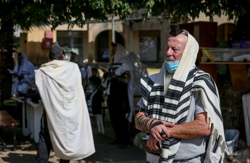 Jewish men pray outside a synagogue in the northern Israeli city of Tzfat, September 23, 2020. (credit: DAVID COHEN/FLASH 90)