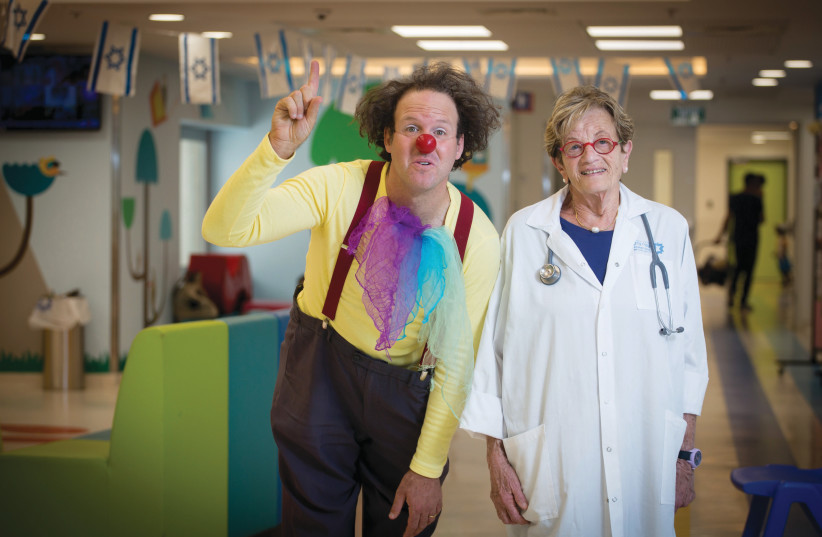 A CLINICIAN and medical clown pose at Shaare Zedek, 2017. The medical center’s emergency rooms are set for an expansion.  (photo credit: MIRIAM ALSTER/FLASH90)