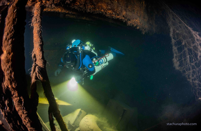 A diver checks the wreck of a German Second World War ship "Karlsruhe" during a search operation in the Baltic sea in June 2020. Polish divers say they have discovered the wreck of a German Second World War ship which may help solve a decades-old mystery - the location of the Amber Room. (photo credit: REUTERS)