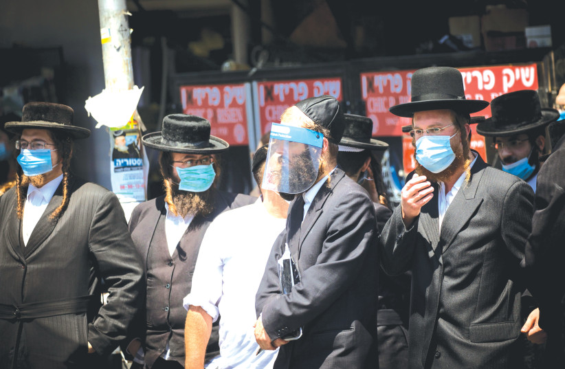 HAREDIM ON a Jerusalem street. Leading rabbis are asking ‘Does the death toll justify shutting down communal life?’  (photo credit: MARC ISRAEL SELLEM/THE JERUSALEM POST)