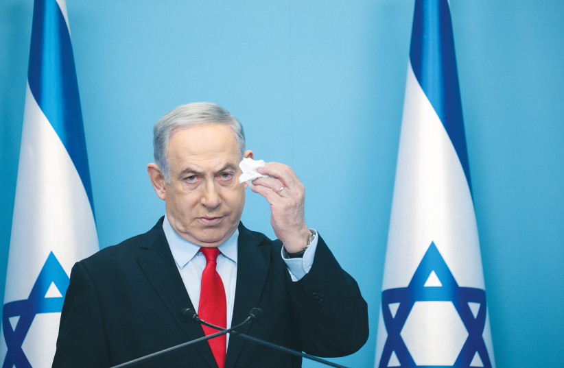 PRIME MINISTER Benjamin Netanyahu encourages Israelis to cover their mouths when they cough or sneeze, during a press conference in Jerusalem on March 12.  (photo credit: OLIVIER FITOUSSI/FLASH90)