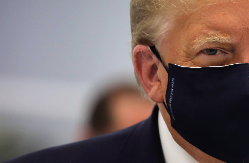 US President Donald Trump wears a protective face mask during a tour of the Fujifilm Diosynth Biotechnologies' Innovation Center, a pharmaceutical manufacturing plant where components for a potential coronavirus disease (COVID-19) vaccine candidate are being developed, in Morrisville, North Carolina (photo credit: REUTERS)
