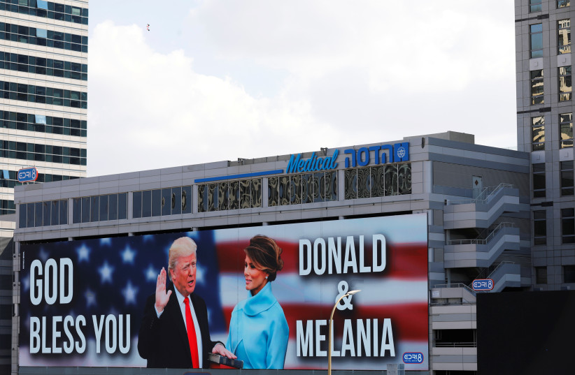 A billboard depicting US President Donald Trump and his wife Melania with the American flag and the words, "God Bless You" is seen along a highway in Tel Aviv, Israel October 4, 2020. (photo credit: AMIR COHEN/REUTERS)