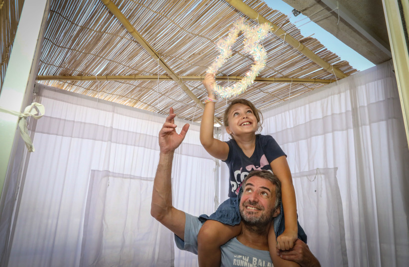 Alain and his daughter, Leni, build a sukkah in Jerusalem before the week-long holiday celebrated in early October (photo credit: MARC ISRAEL SELLEM)
