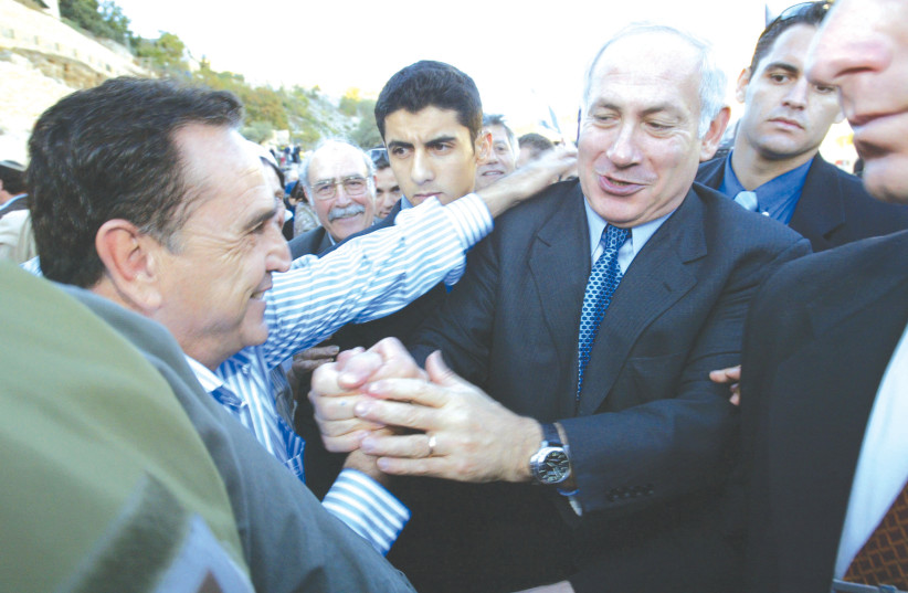 PRIME MINISTER Benjamin Netanyahu shakes hands with supporters during a Likud meeting in 2007. ‘Why speak to 500 people when we can be speaking to a million?’ (photo credit: OLIVIER FITOUSSI/FLASH90)