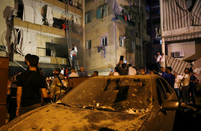 People gather as rescuers evacuate people from their buildings after a fuel tank exploded in the al-Tariq al-Jadida neighborhood of Beirut (photo credit: REUTERS/ISSAM ABDALLAH)