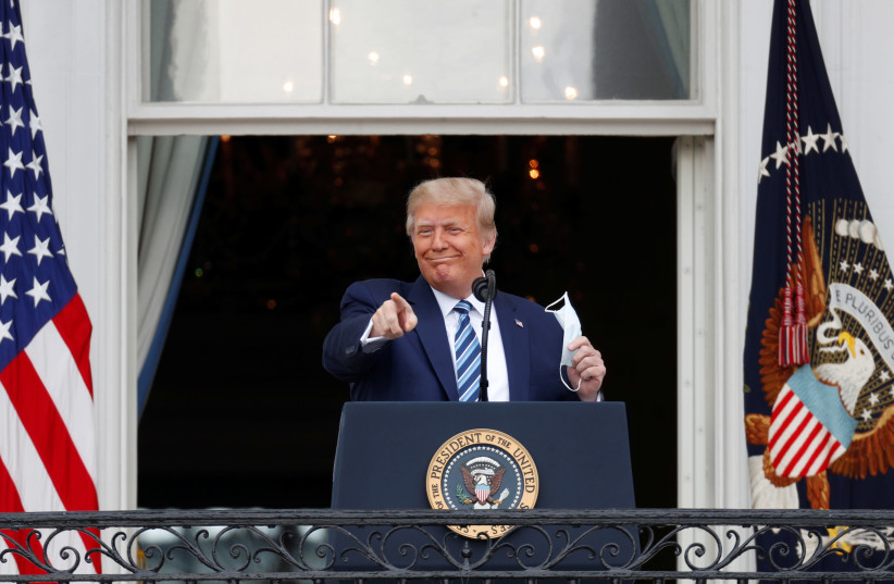 U.S. President Donald Trump gestures as he stands on a White House balcony speaking to supporters gathered on the South Lawn for a campaign rally that the White House is calling a "peaceful protest" in Washington, U.S., October 10, 2020 (photo credit: REUTERS/TOM BRENNER)