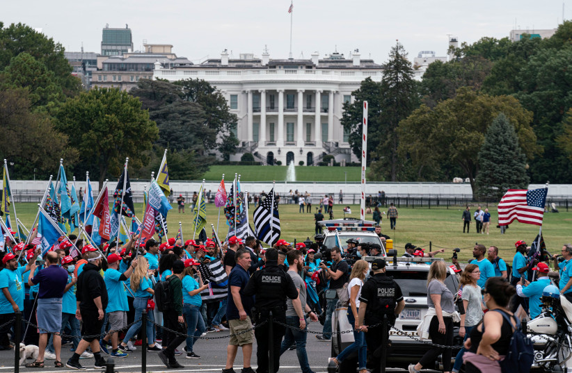 Supporters of US President Donald Trump rally and march on the Ellipse and the streets around the White House after the president's campaign rally on the South Lawn of the White House in Washington, October 10, 2020.  (photo credit: REUTERS/KEN CEDENO)