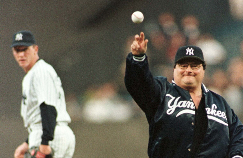 Under the eyes of New York Yankees starter David Cone (L), Wayne Knight, who plays Newman on the hit TV show "Seinfeld," tosses the ceremonial first pitch before the Yankees game with the Texas Rangers May 13 at Yankee Stadium. (photo credit: REUTERS)