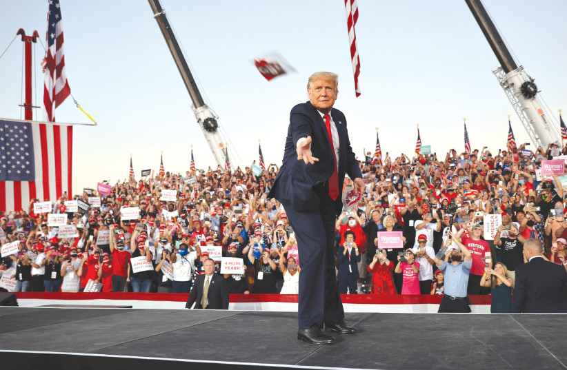 Trump tosses face masks to the crowd as he takes the stage in Florida for his first campaign rally since being treated for COVID-19. 12 October 2020 (photo credit: JONATHAN ERNST / REUTERS)