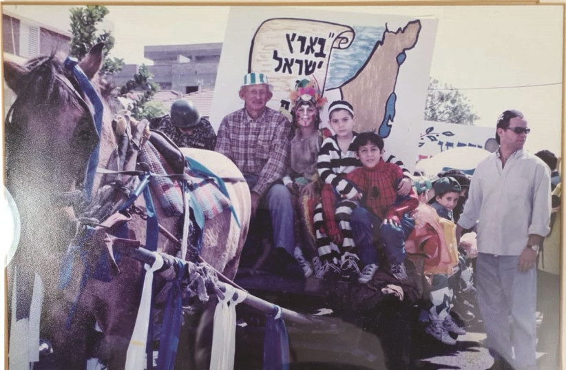 ON PURIM, instead of hauling heavy supplies, Netanya’s wagon drivers donned costumes and decorated horses and wagons. Pictured: Eliahu Parobic (left), who provided fun-filled rides for families.  (photo credit: Courtesy)