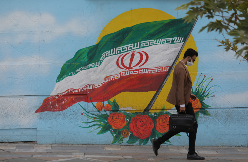 A MAN WALKS on a Tehran street this week. Iranian President Hassan Rouhani declared this week that ‘from Sunday we can sell our weapons to whomever we want and buy weapons from whomever we want.’ (credit: REUTERS)