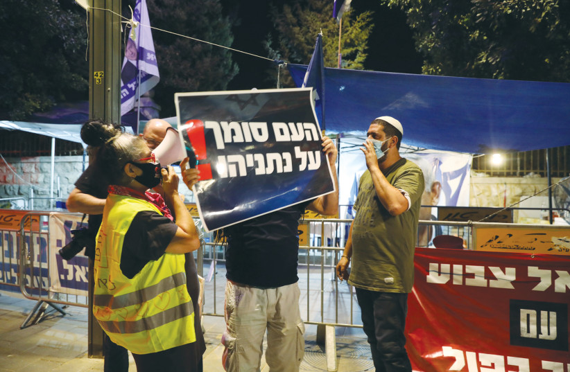 ISRAELIS HOLD A counter-protest in support of Benjamin Netanyahu close to a demonstration against him near the prime minister’s official residence in Jerusalem last week. The sign reads: ‘The people trust Netanyahu!’  (photo credit: MARC ISRAEL SELLEM/THE JERUSALEM POST)